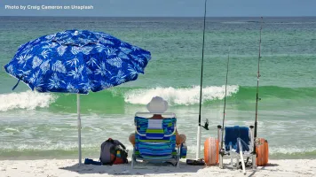 A man relaxing, fishing at the beach.