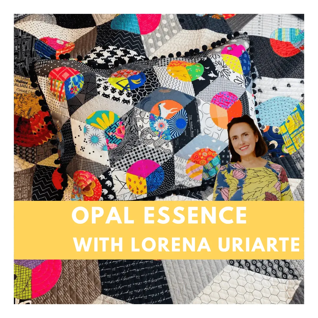 Colorful whimsical quilt with triangular circus tents, toys, and geometric shapes on a pink background bordered with colorful triangles and diamonds. No human shapes or faces.