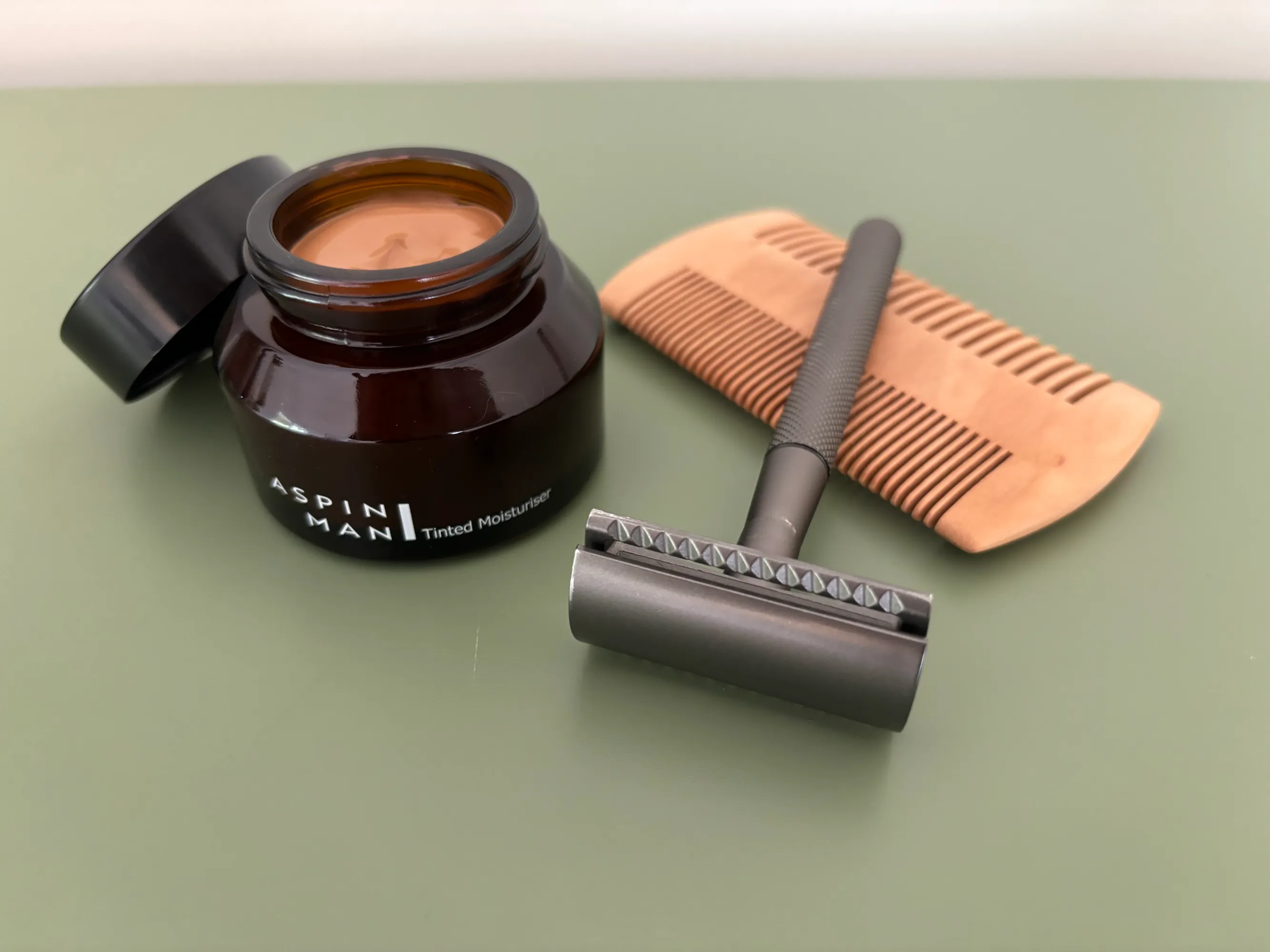 Close-up of luxury shaving tools with rich textures and subtle lighting on a marble surface. No human shapes.