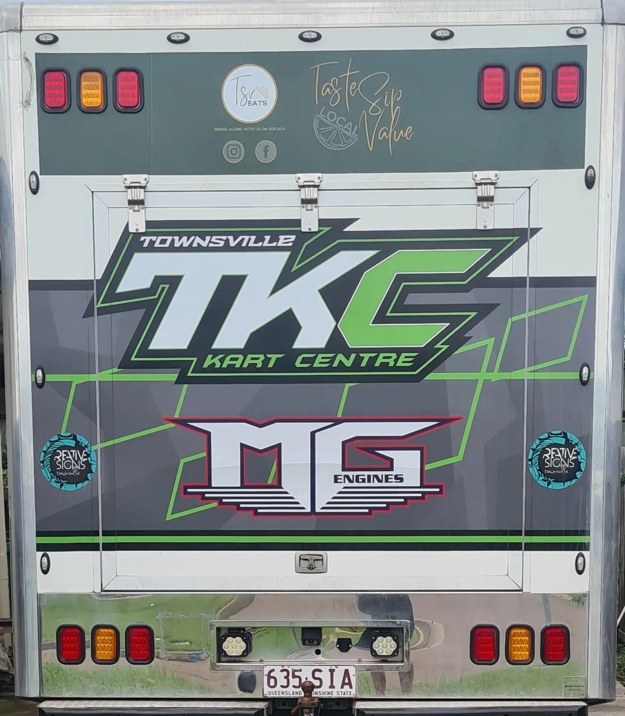 Racing kart being transported and stored properly in a professional facility. Shows secure kart storage bays and transport vehicle. No human shapes.