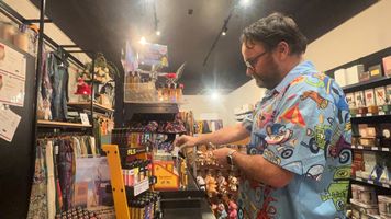 Jonathon arranging products beside an incense and giftware display inside the Wicks n Bits Belmont store.